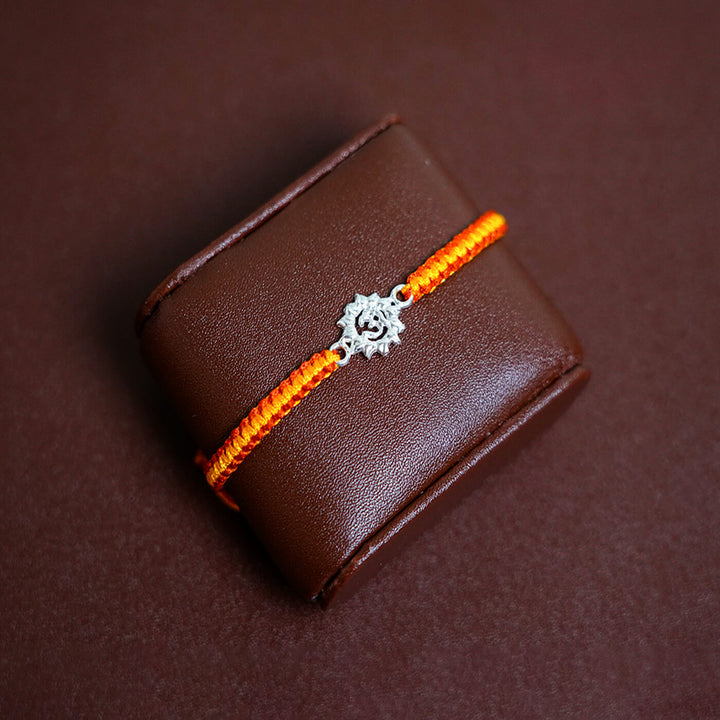 Handcrafted Silver Motif Adjustable Rakhi With Rice Roli 2 - Bracelet Displayed on Cushion