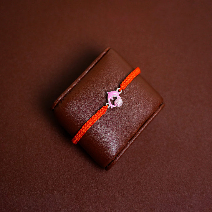 Handcrafted Silver Motif Adjustable Rakhi For Kids With Rice Roli 3 - Front View on Display Cushion