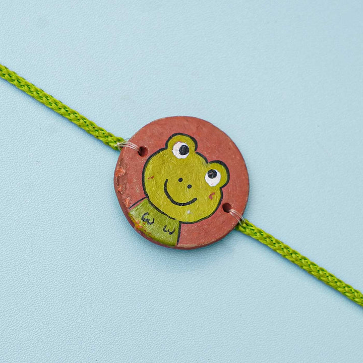 Hand Painted Frog Terracotta Rakhi With Roli Chawal For Kids Copy - Close-up of Frog Charm