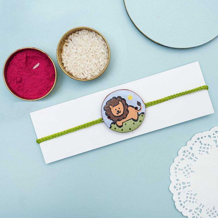 Personalized Animal Theme Terracotta Rakhi With Roli Chawal For Kids 3 - Styled Flat Lay with Accessories