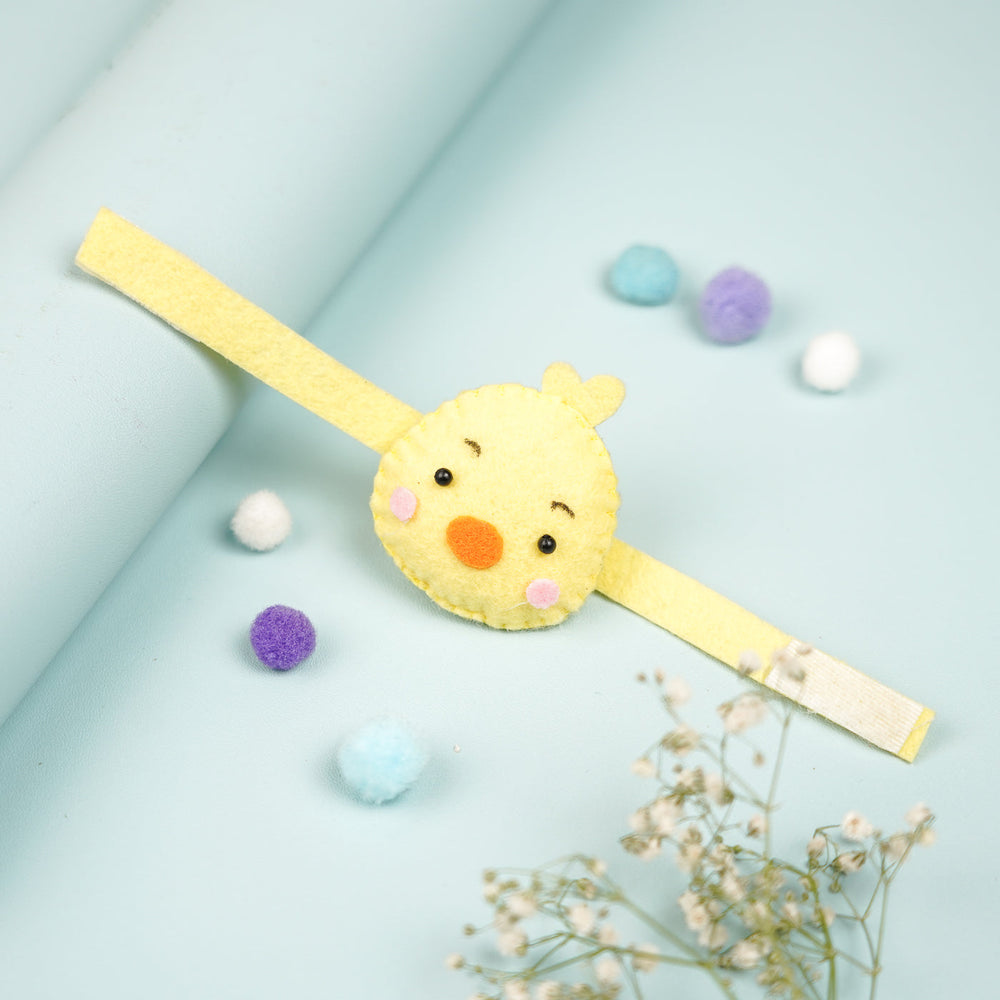 Handmade Duck Theme Felt Kids Rakhi With Roli Chawal - Top View on Curved Surface