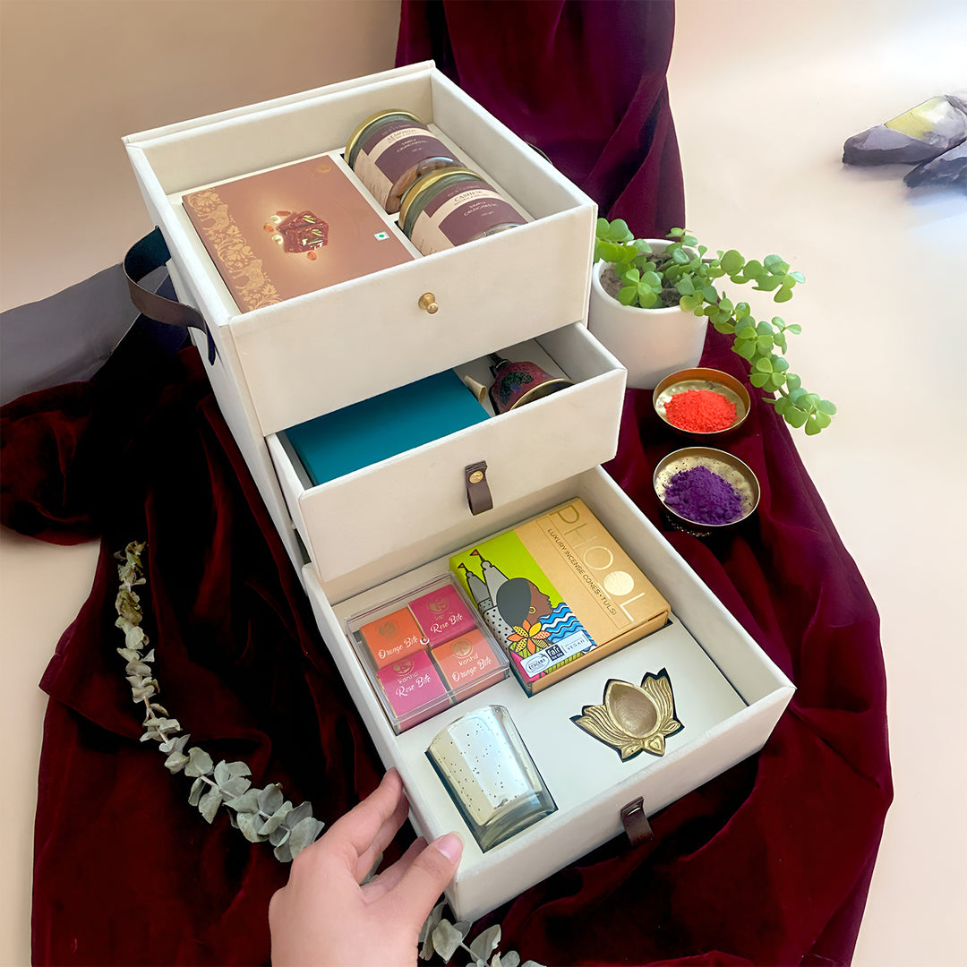 The Ivory Glow Diwali Gift Hamper | Includes 1 Doda Barfi, 2 Dry Fruit Jars, 1 Pooja Bell, 1 Pooja Samagri, 4 Assorted Bites, 1 Incense Cones Pack, 1 Brass Diya, 1 Candle, 1 Gift Box