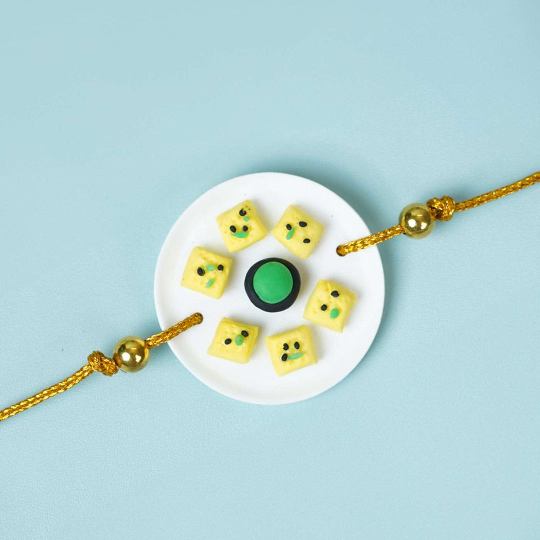 Handmade Miniature Clay Dhokla Rakhi With Roli Chawal - Close-up of Rakhi design