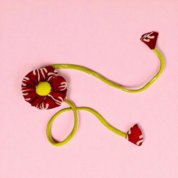 Handmade Floral Pom Pom Upcycled Fabric Rakhi With Roli Chawal For Brother - Flat Lay with Twisted Cable