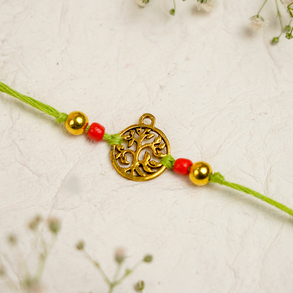 Orange Green Pearl And Tree Charm Resin Bracelet Rakhi With Roli Chawal For Bhaiya And Bhabhi - Close-up of Charm Detail