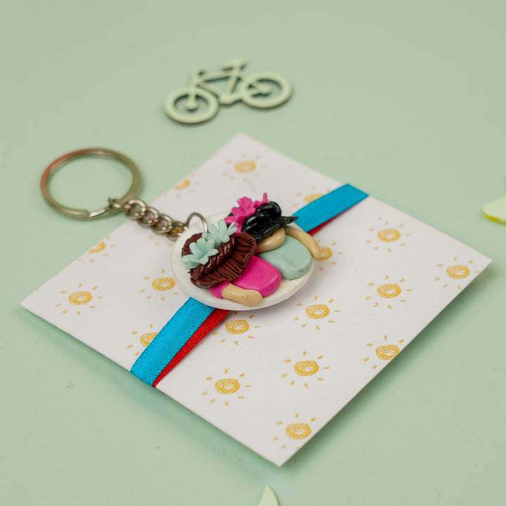 Handmade Reusable Twin Sisters Keychain Clay Rakhi With Roli Chawal - Angled View on Card