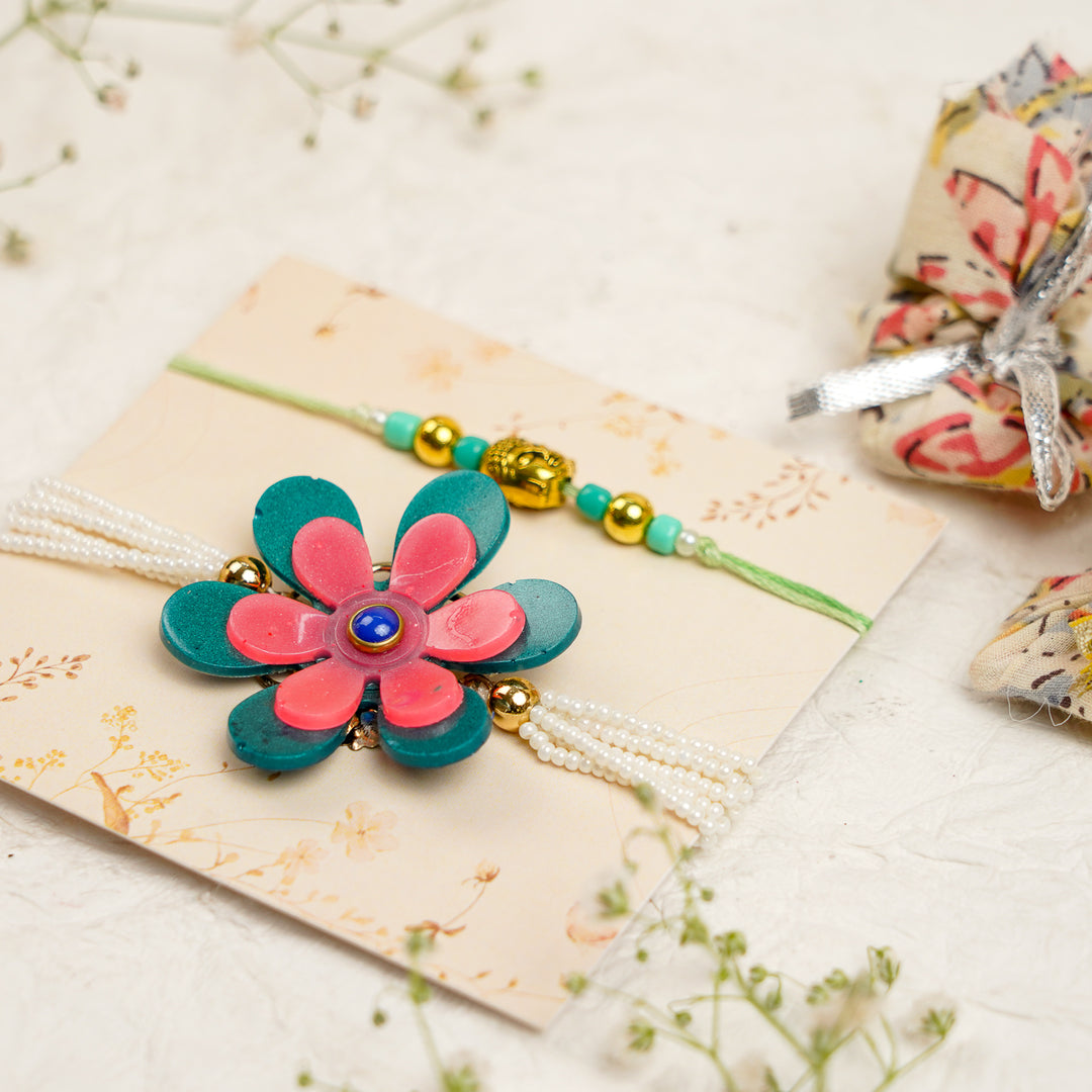Green Pink Pearl And Buddha Charm Resin Bracelet Rakhi With Roli Chawal For Bhaiya And Bhabhi - Angled View with Props
