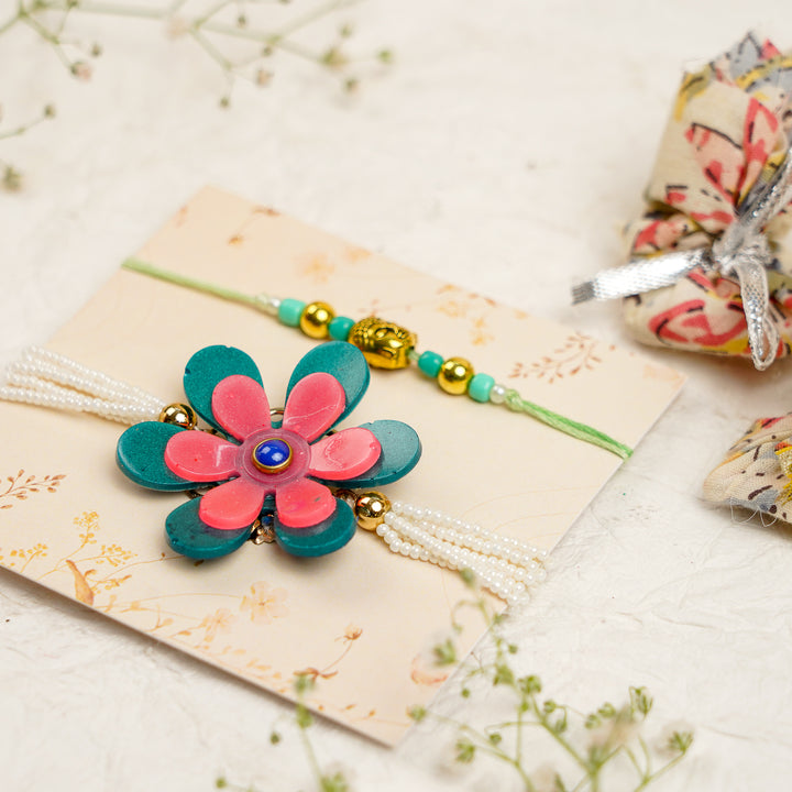 Green Pink Pearl And Buddha Charm Resin Bracelet Rakhi With Roli Chawal For Bhaiya And Bhabhi - Angled View with Props