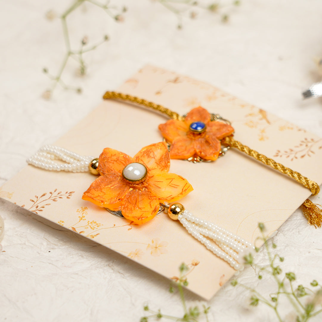 Orange Pearl And Dori Resin Bracelet Rakhi With Roli Chawal For Bhaiya And Bhabhi - Angled View on Card Display