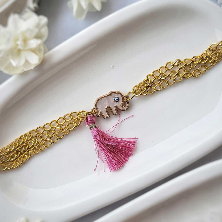 Handmade Elephant Design Bracelet Rakhi Hamper With Roli Chawal For Sisters - Close-up of bracelet with pink tassel