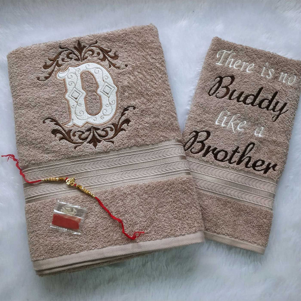 Personalized Embroidered Beige Cotton Towel Rakhi Hamper With Roli Chawal For Brother Includes 1 Hand Towel 1 Bath Towel And 1 Rakhi - Front View Showing Towels and Rakhi