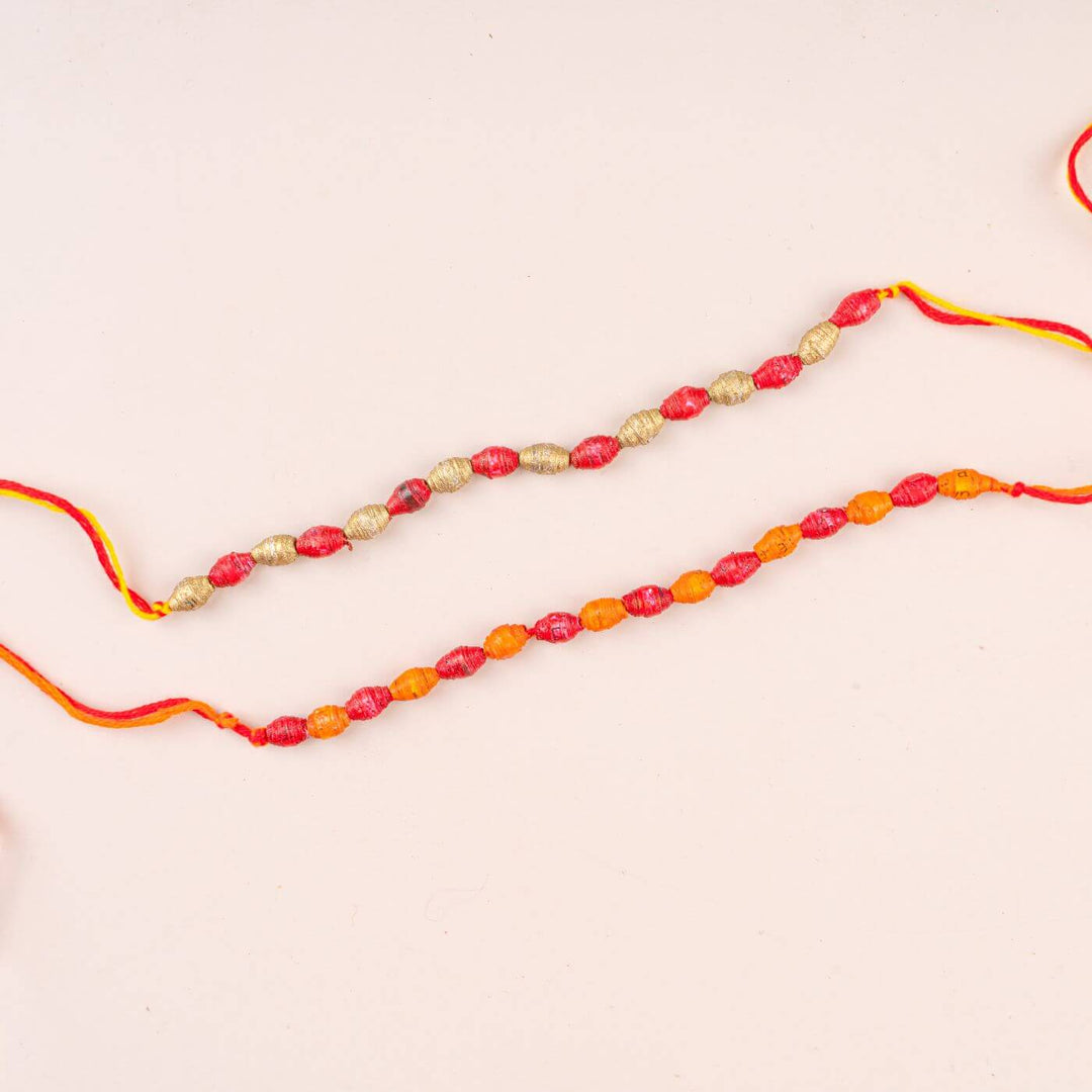 Handcrafted Paper Beads Rakhi Hamper With Rice Roli 1 - Close-up of Two Rakhis