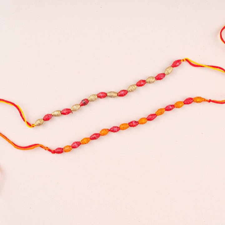 Handcrafted Paper Beads Rakhi Hamper With Rice Roli 1 - Close-up of Two Rakhis
