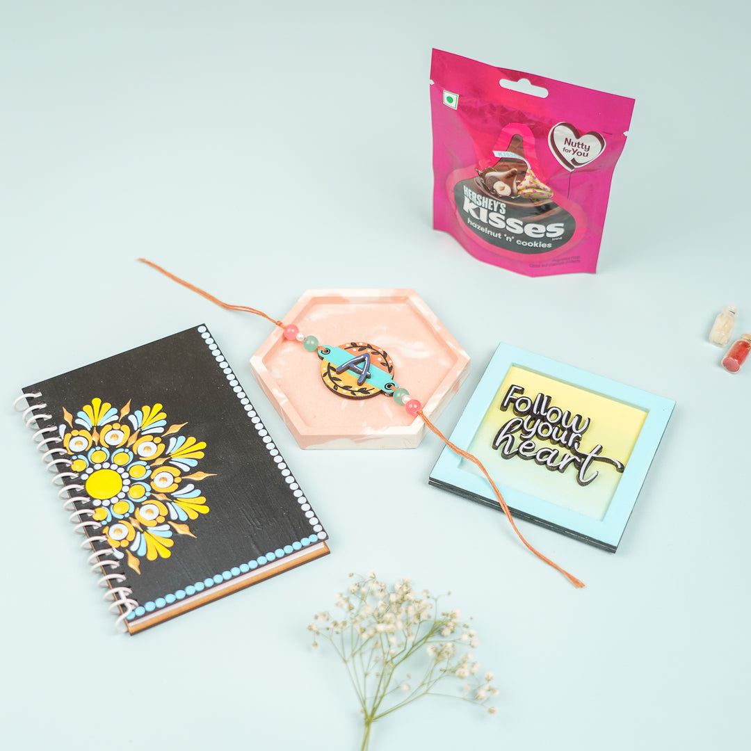 Photo Personalized Handmade Rakhi Hamper For Brother Includes 1 Diary 1 Coaster 1 Fridge Magnet 1 Rakhi 1 Chocolate - Gift Set Layout with Pink Packaging