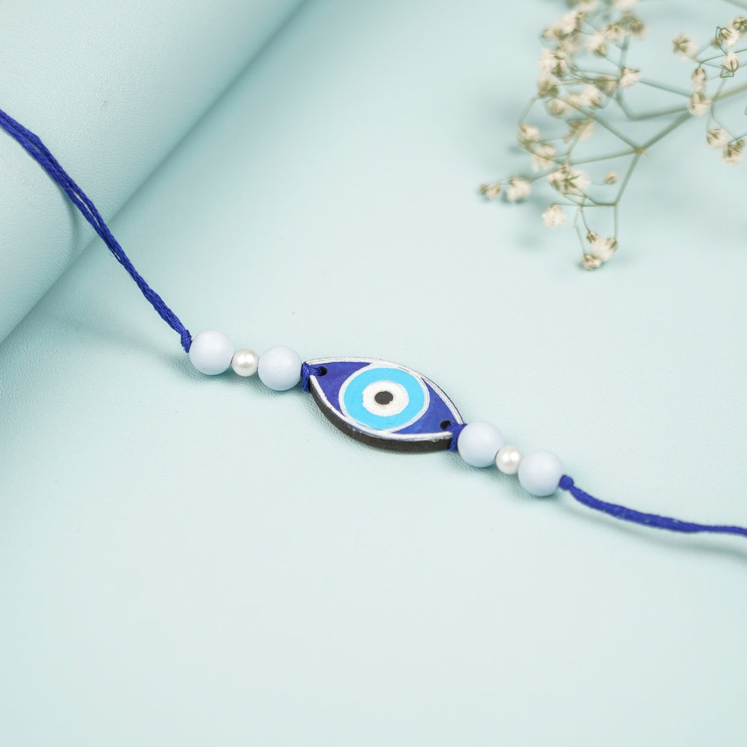 Customized Hand Painted Evil Eye Design Mdf Wood Rakhi - Close-up on Blue Beaded Bracelet