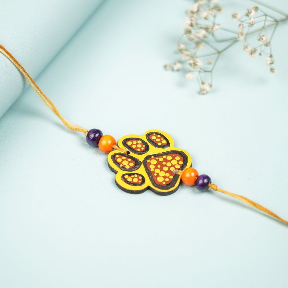 Hand Painted Paw Design Mdf Wood Kids Rakhi - Flat Lay Display on Surface