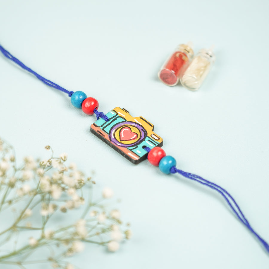 Customized Hand Painted Camera Design Mdf Wood Rakhi - Close-up Front View with Decoration