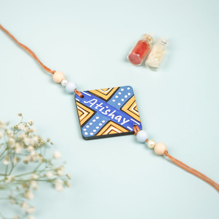 Personalized Hand Painted Round Design Mdf Wood Rakhi - Top View with Name Personalization