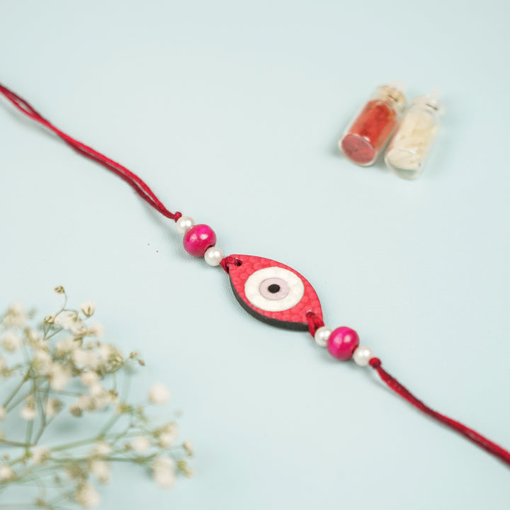 Customized Hand Painted Evil Eye Design Mdf Wood Rakhi - Front View Showing Pink Beads Close-up