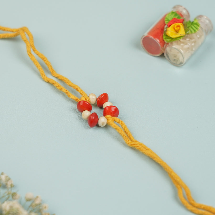 Handmade Red And White Gunj Flower Design Seed Rakhi For Brother - Close-up of Bracelet Detail