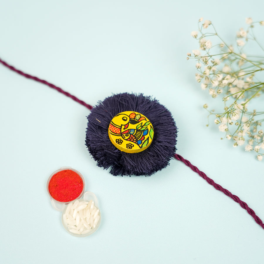 Hand Painted Madhubani Black Peacock Design Wooden Rakhi With Roli Chawal For Brother - Top View with Color Powders