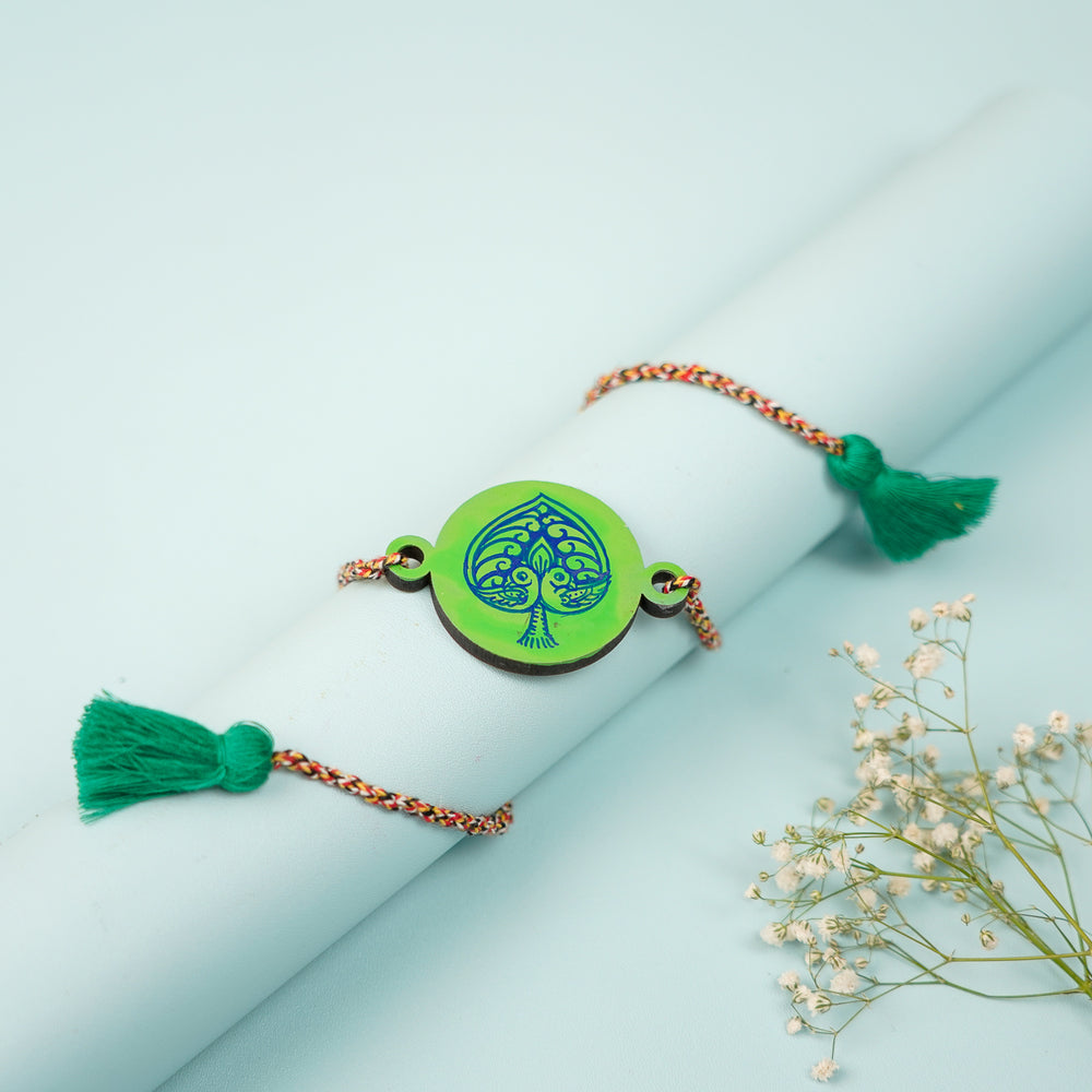 Hand Painted Pattachitra Peacock Heart Design Wooden Rakhi With Roli Chawal For Brother - Styled Draped View on Cylinder