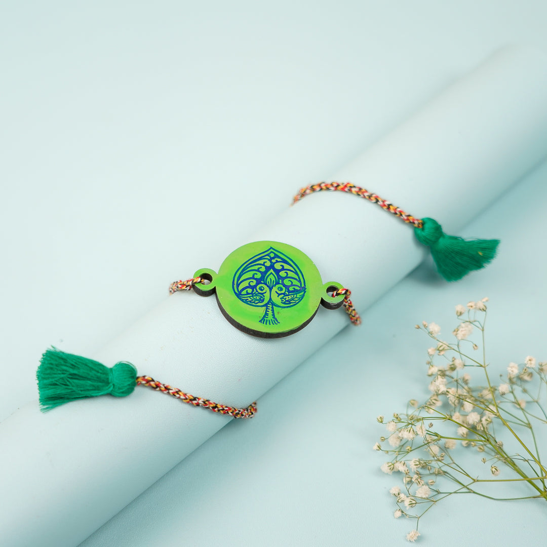 Hand Painted Pattachitra Peacock Heart Design Wooden Rakhi With Roli Chawal For Brother - Styled Draped View on Cylinder