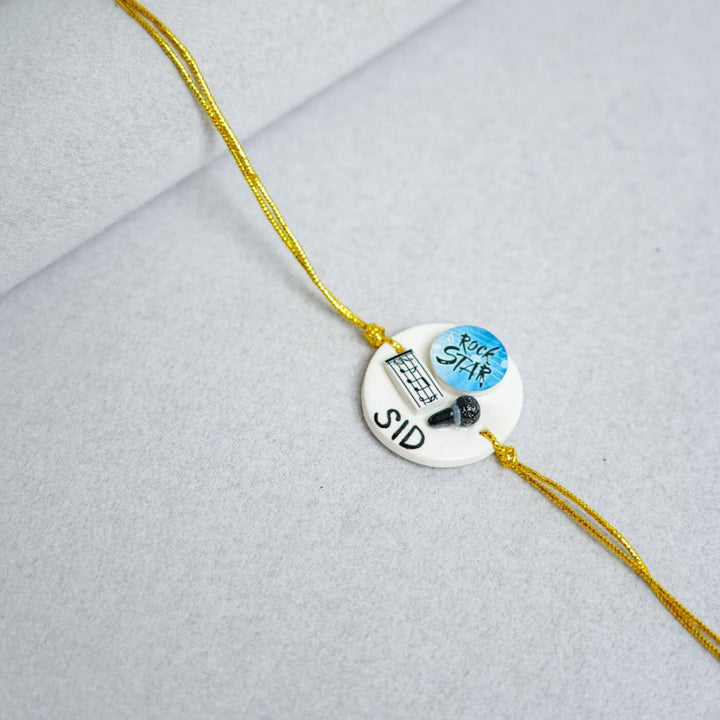Handmade Personalized Clay Rakhi Keychain With Roli Chawal 1 - Music Theme Close-up