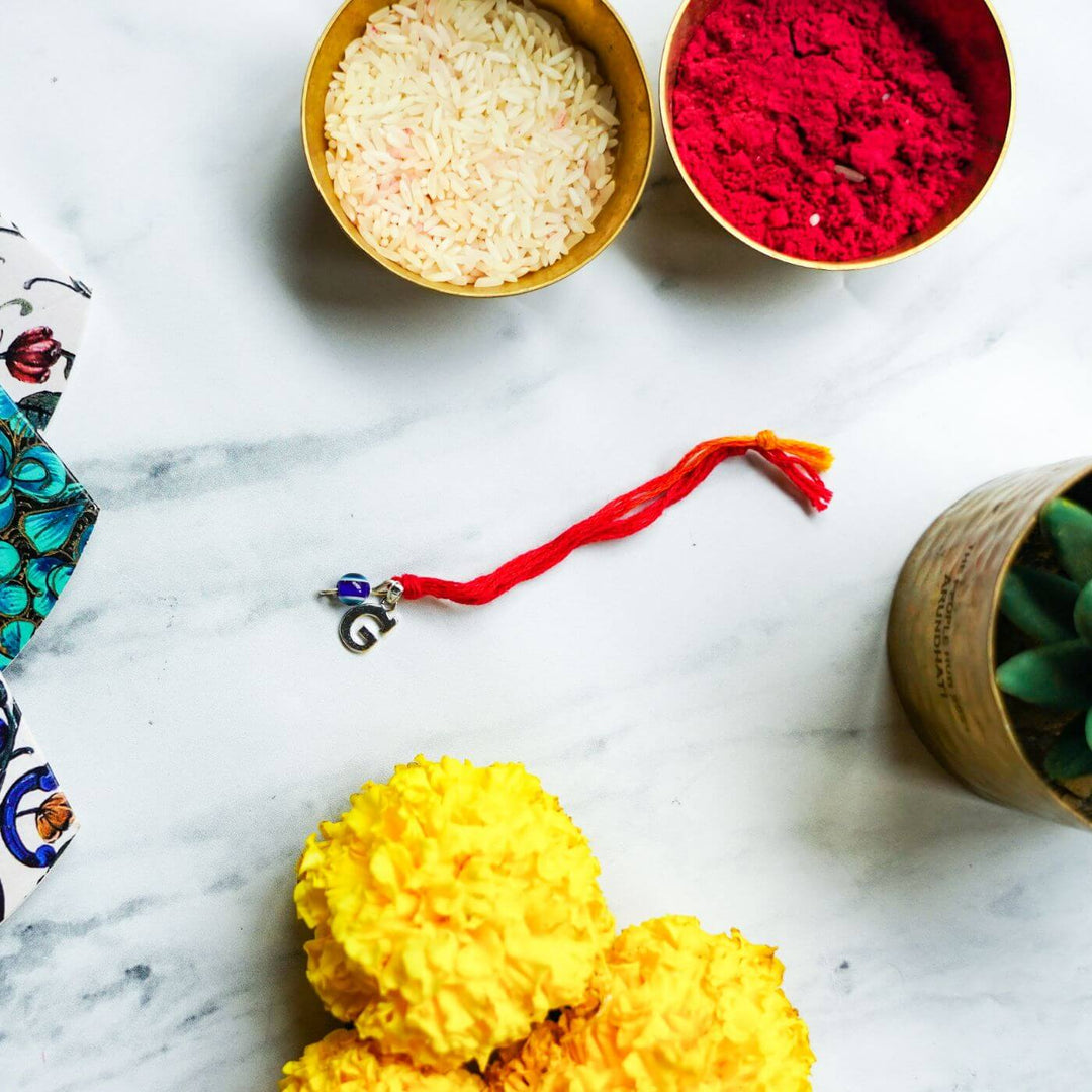 Handcrafted Silver Ganesha Rakhi With Rice Roli - Rakhi with Festive Elements