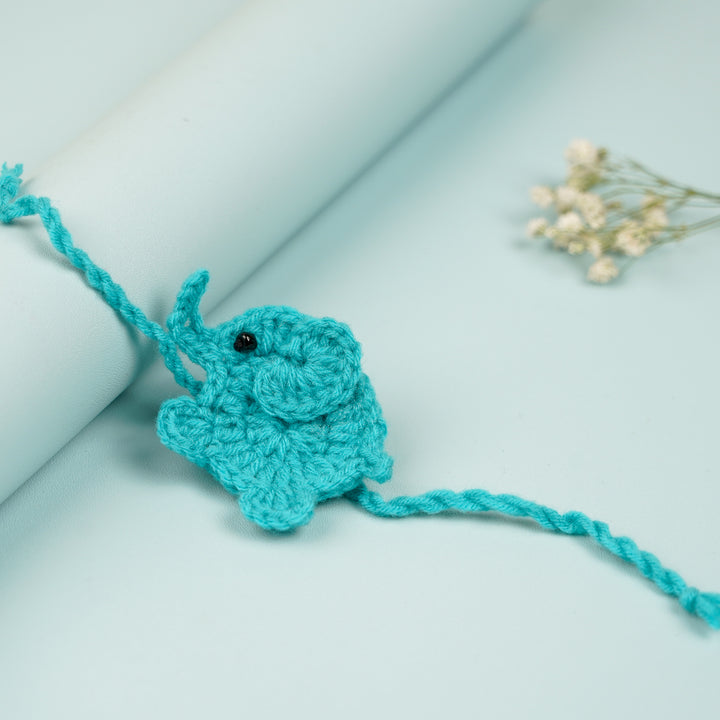 Handmade Crochet Elephant Theme Kids Rakhi With Roli Chawal - Close-up with Rolled Background