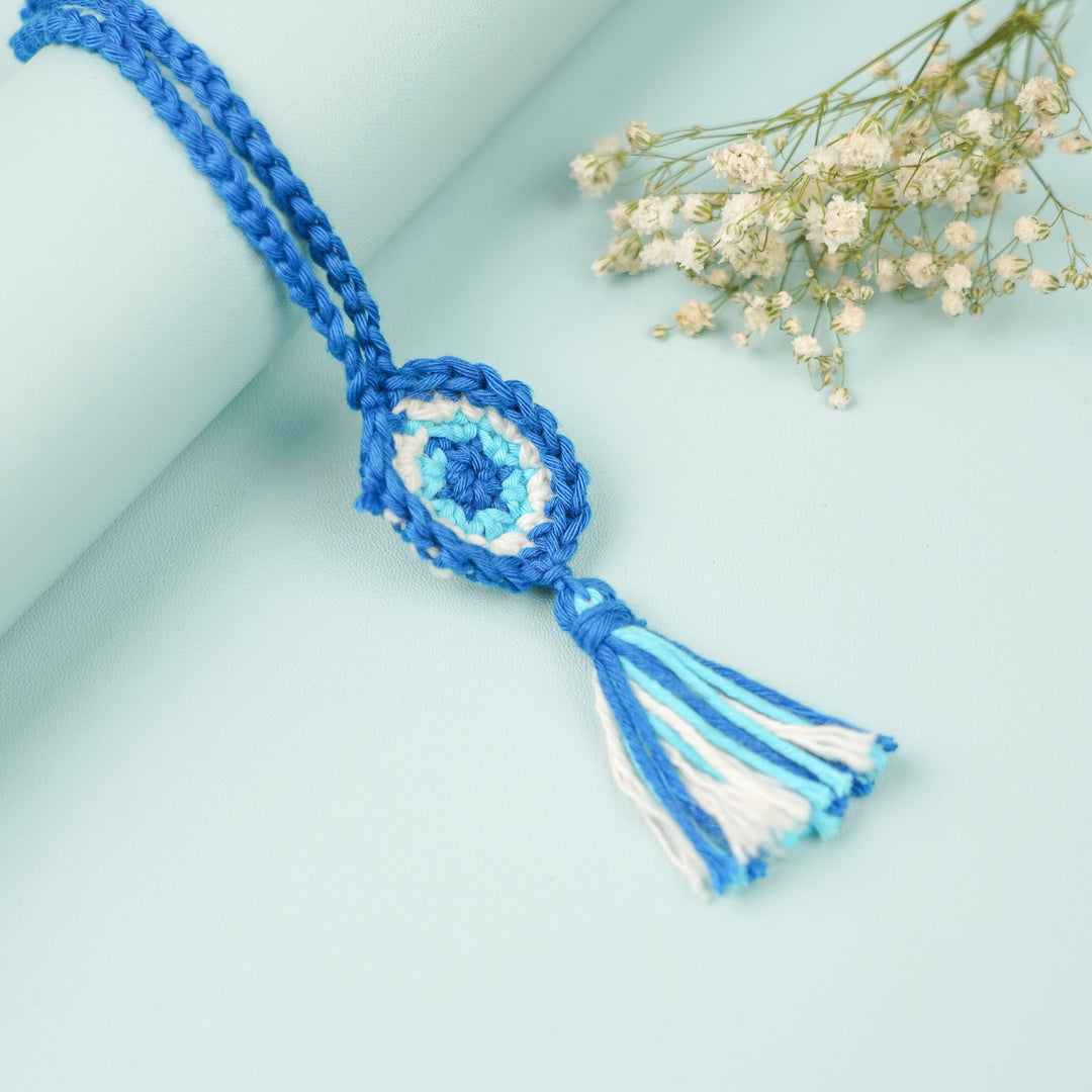 Handmade Crochet Evil Eye Lumba Rakhi For Bhabhi With Roli Chawal - Top view of woven tassel accessory