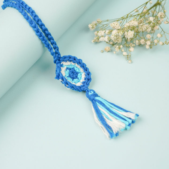 Handmade Crochet Evil Eye Lumba Rakhi For Bhabhi With Roli Chawal - Top view of woven tassel accessory