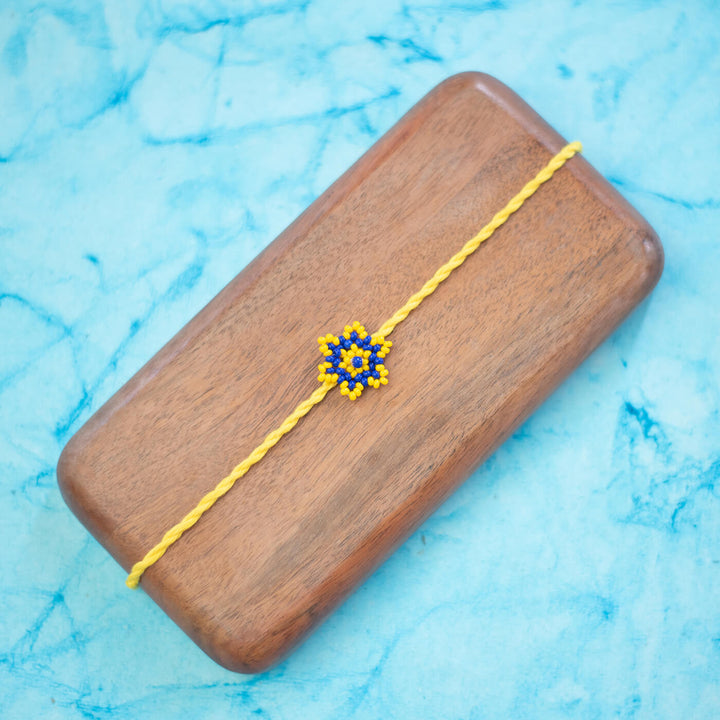 Sitara Collection Glass Beeds Rakhi Yellow Blue - Flat Lay Front View on Wooden Box