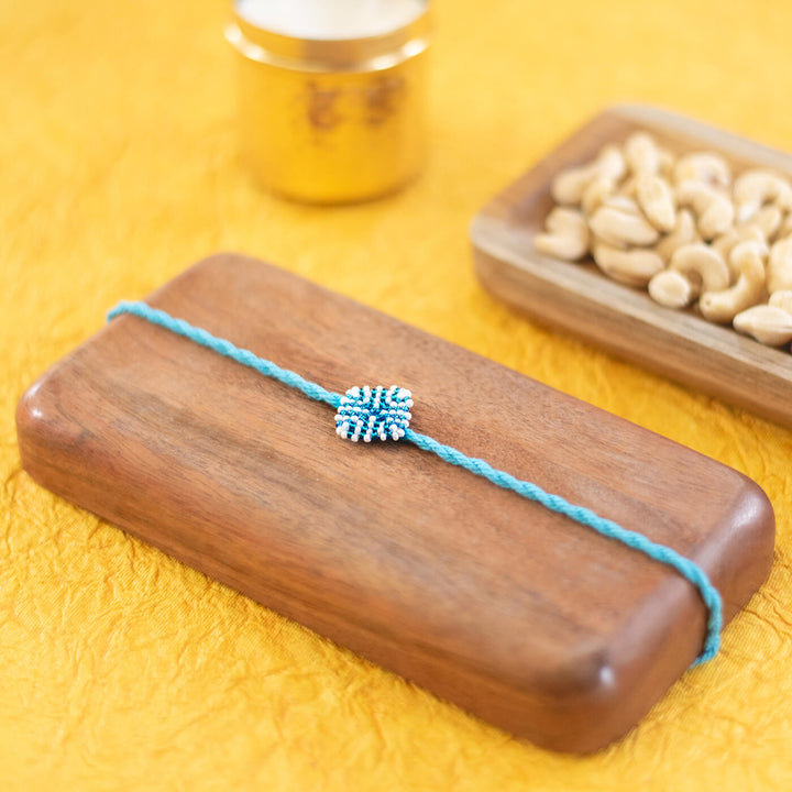 Raksha Collection Glass Beeds Rakhi Sky Blue - Styled flat lay with props