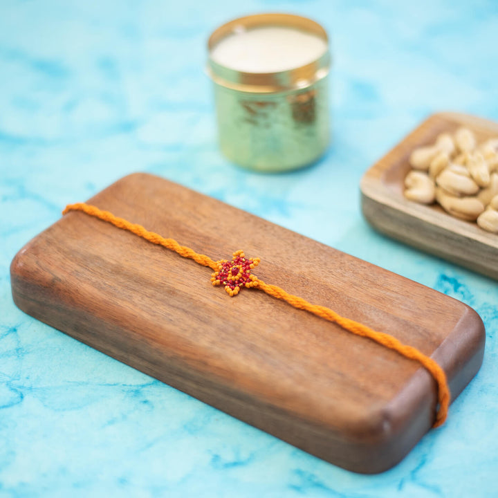 Sitara Collection Glass Beeds Rakhi Orange Red - Styled Product Placement with Props
