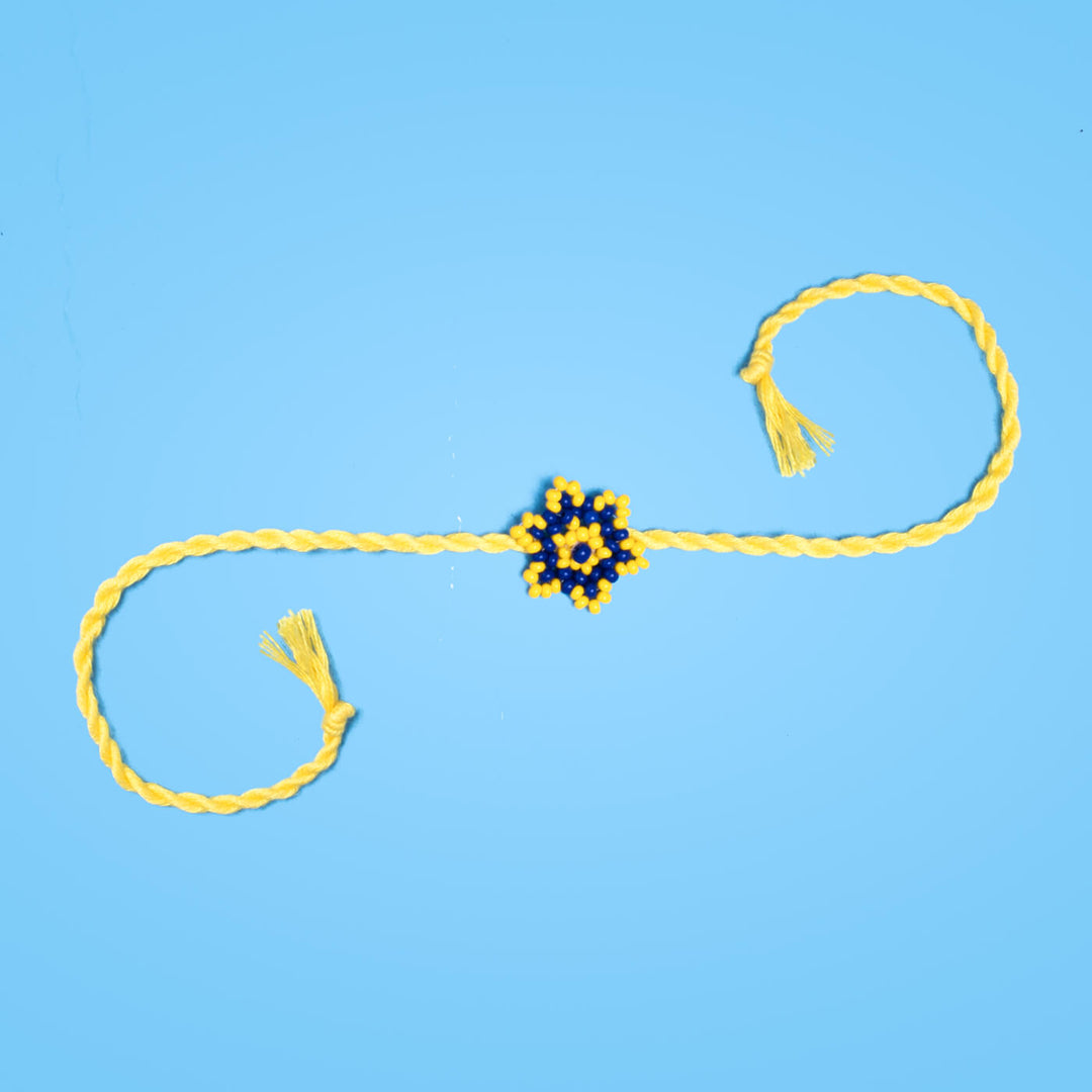 Sitara Collection Glass Beeds Rakhi Yellow Blue - Full Length on Blue Background