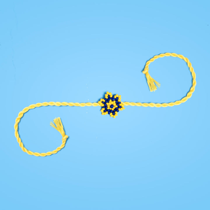 Sitara Collection Glass Beeds Rakhi Yellow Blue - Full Length on Blue Background