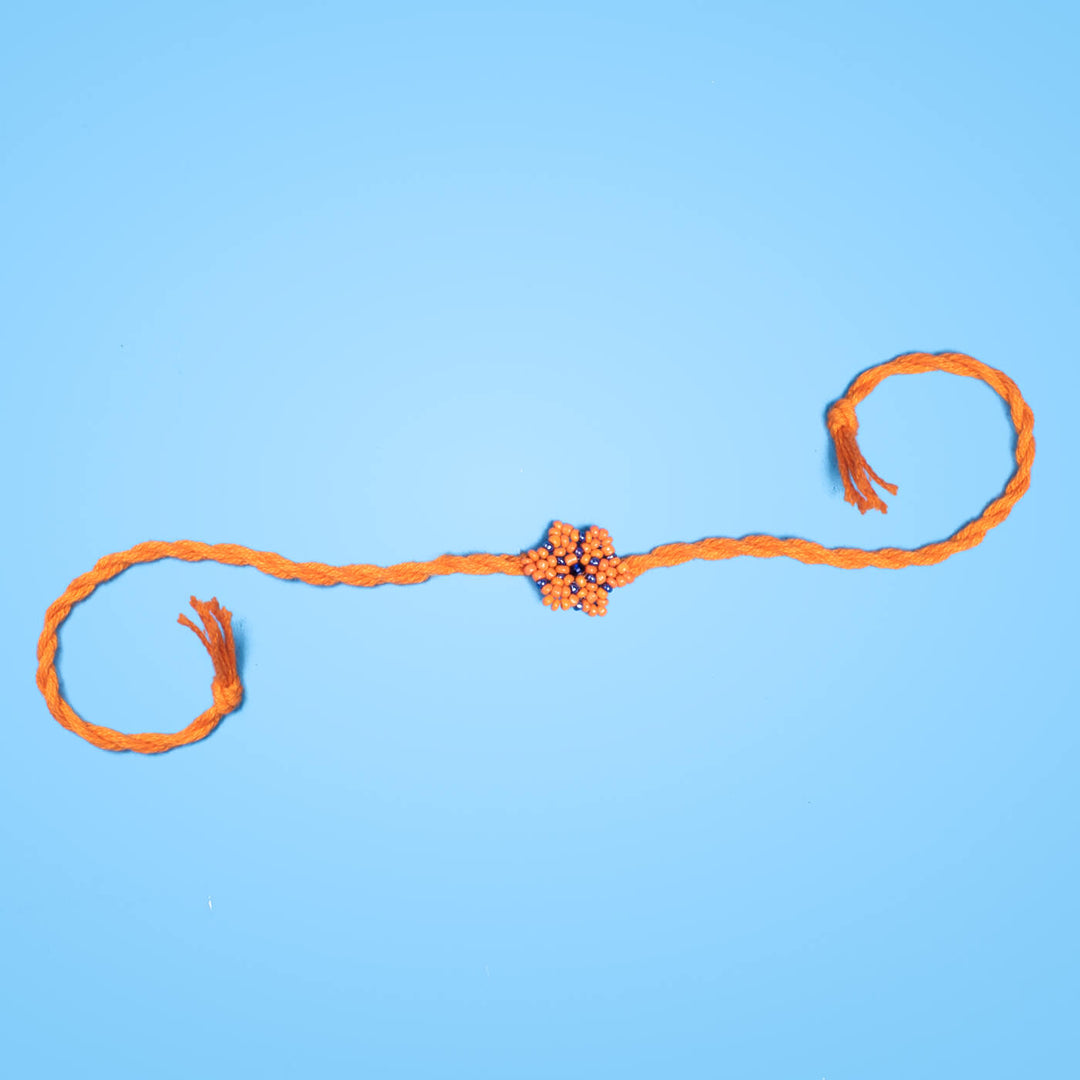 Phool Collection Glass Beeds Rakhi Orange Blue - Full stretched product on blue background