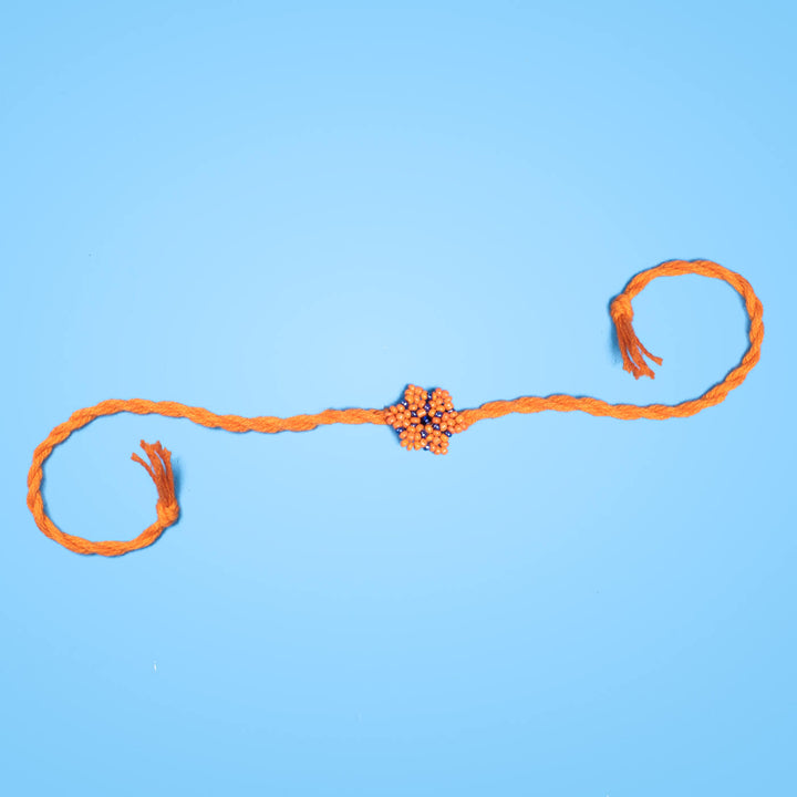 Phool Collection Glass Beeds Rakhi Orange Blue - Full stretched product on blue background