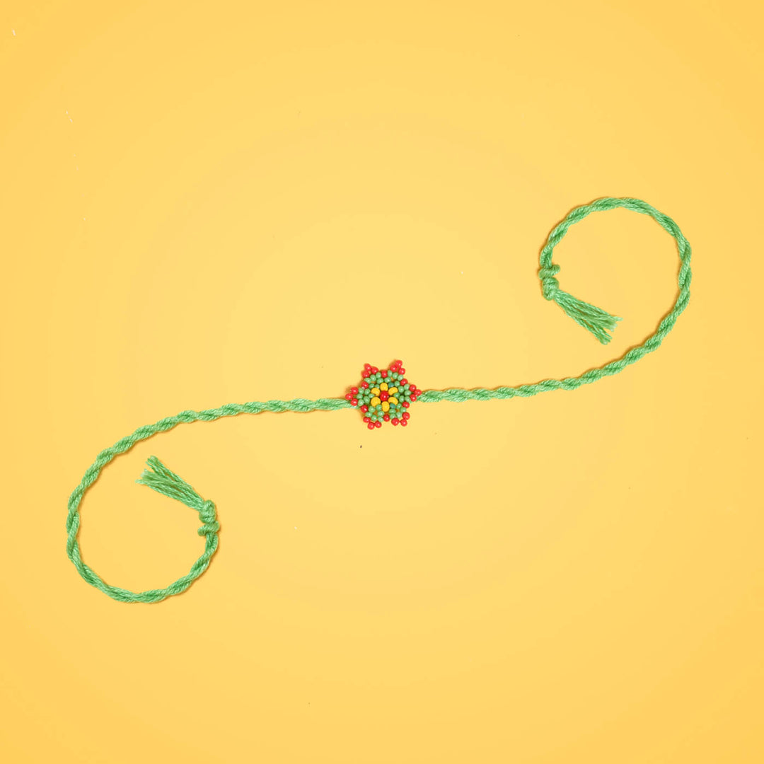Sitara Collection Glass Beeds Rakhi Green - Full Product Display on Yellow Background