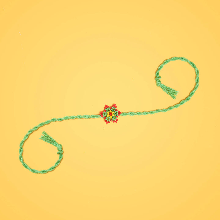 Sitara Collection Glass Beeds Rakhi Green - Full Product Display on Yellow Background