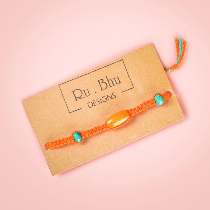 Orange Macrame Cotton Rakhi With Orange Teal Beads - Bracelet on Brand Card