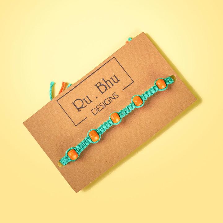 Teal Macrame Cotton Rakhi With Orange Beads - Bracelet on branded card