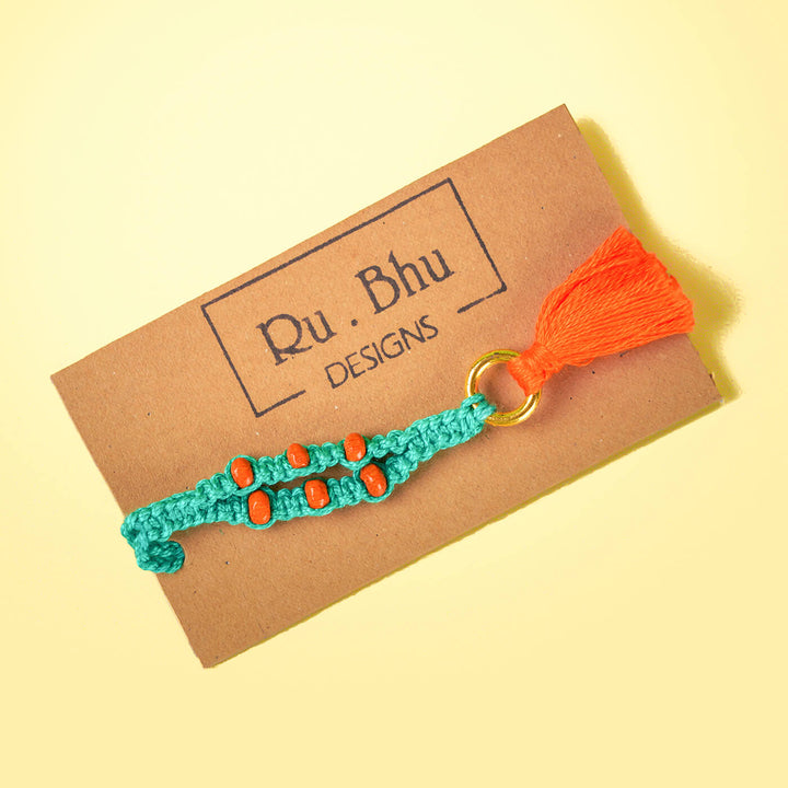 Teal Macrame Cotton Rakhi With Orange Beads Tassle - Bracelet on branded display card