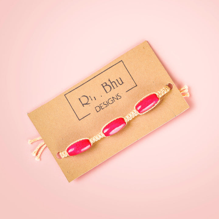 White Macrame Cotton Rakhi With Pink Beads - Product on Branded Card