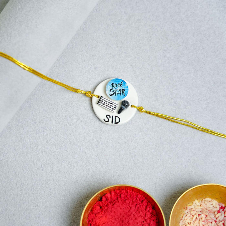 Handmade Personalized Rakhi Keychain With Roli Chawal 3 - Rakhiya on surface with colors