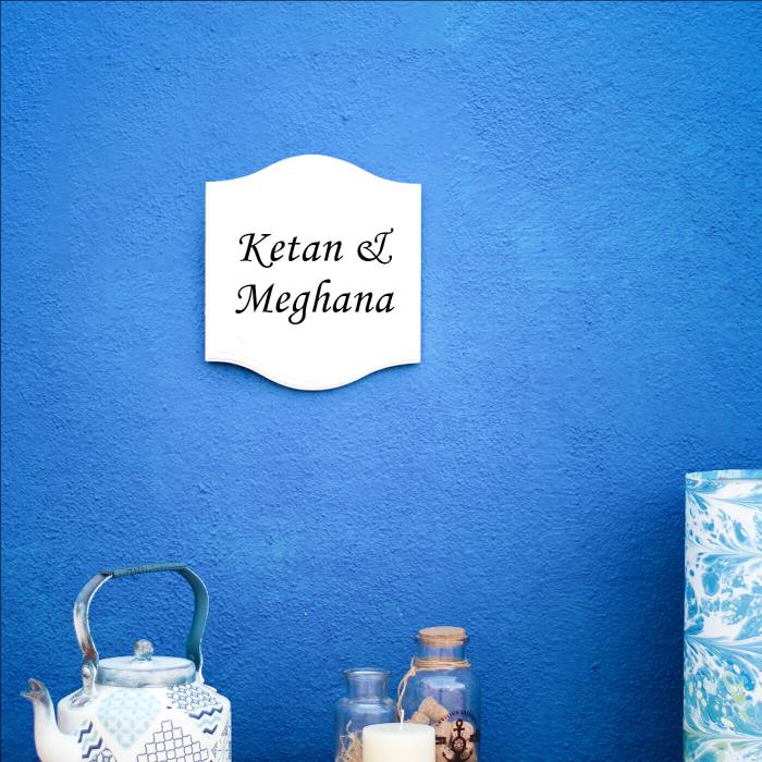 White Small Vertical Curved Name Plate Couple Name - Mounted on Blue Wall Front View